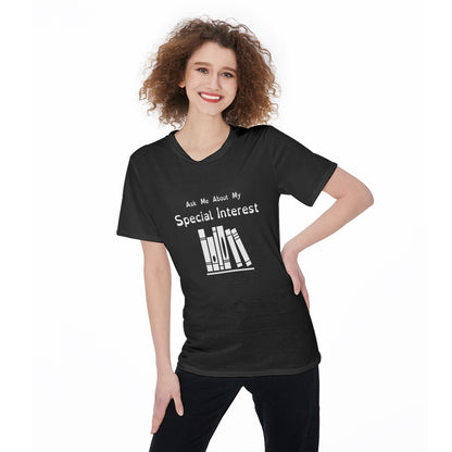 Fair-skinned fem-presenting model with curly hair wearing a black tshirt with white logo and text. Text: Ask Me About My Special Interest. Logo, below: 6 Stylized books on a shelf.