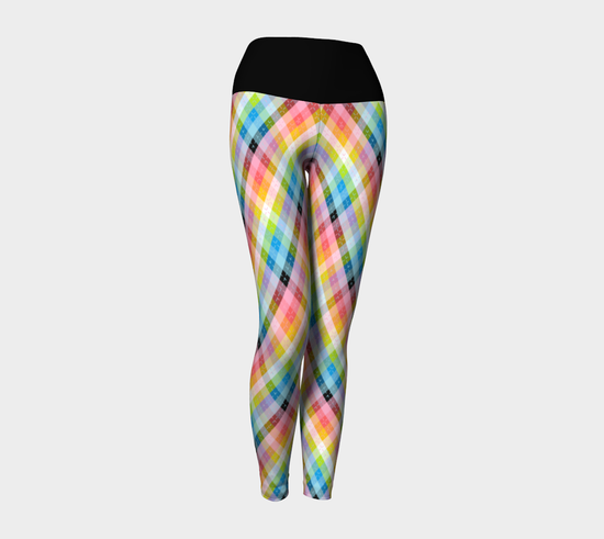 Image of a pair of yoga leggings. They have a wide black waistband, and argyle plaid pattern on the legs, in the queer pride flag colours.
