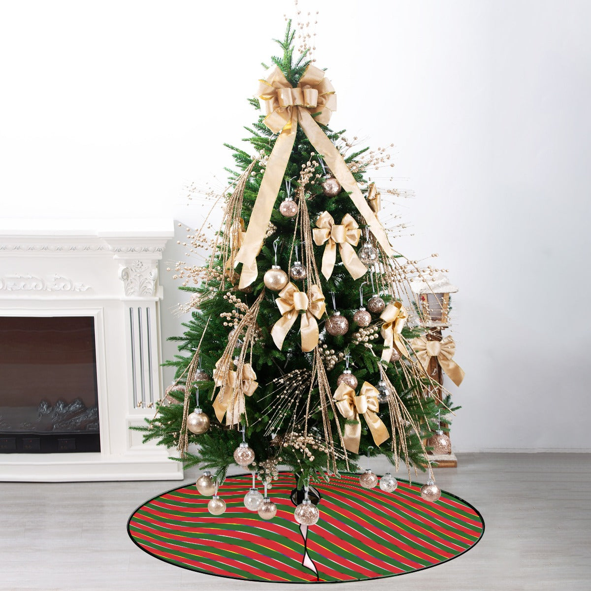 Photo of a small Christmas tree with gold decorations. It has a tree skirt with wide red and green stripes, and narrow rainbow stripes.