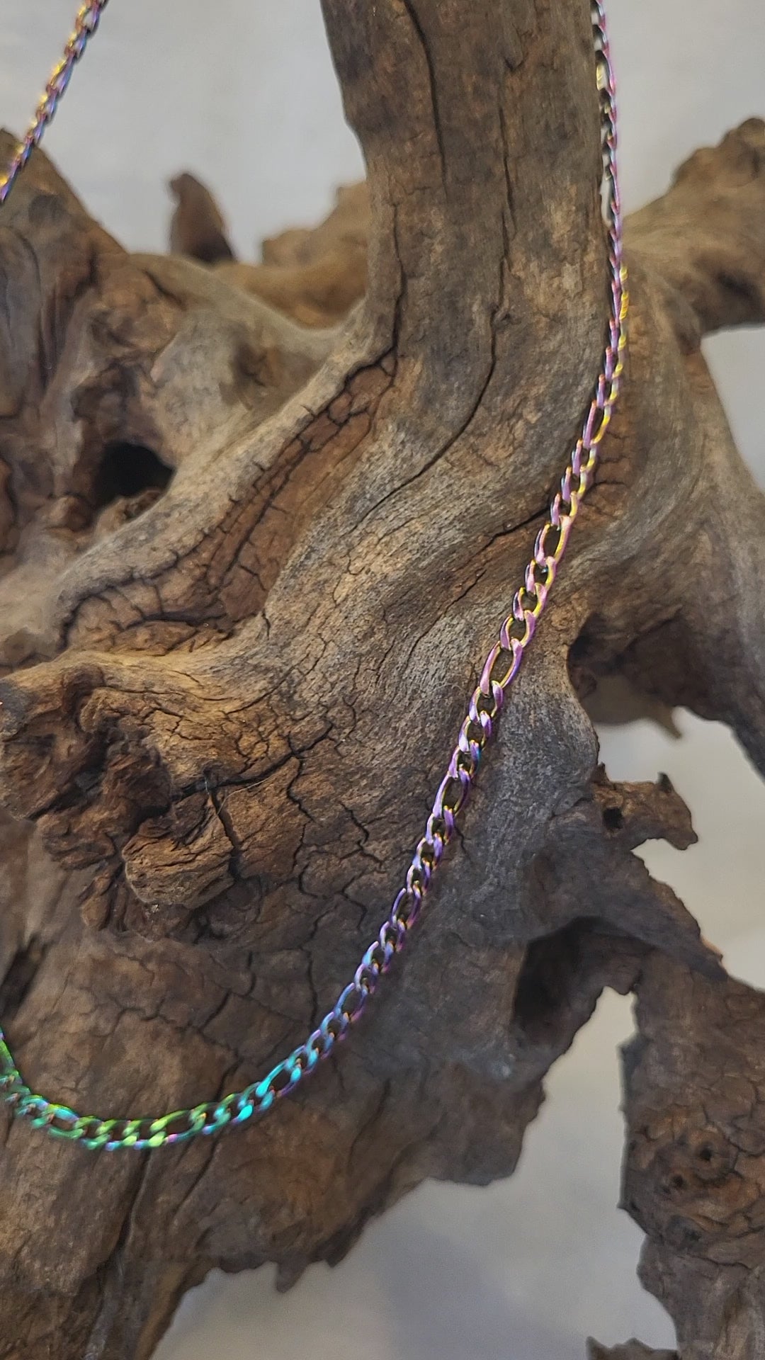 Short video of the figaro chain necklace hanging from a piece of driftwood. The video rotates side to side, then up an down, to show the shine and colour variation.